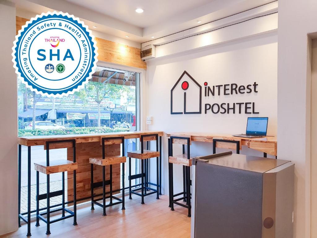 a bar with stools and a sign for an interest posted at INTERest POSHTEL in Bangkok