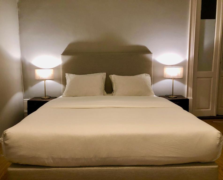 um quarto com uma grande cama branca e 2 candeeiros em Porto Republica Downtown em Porto