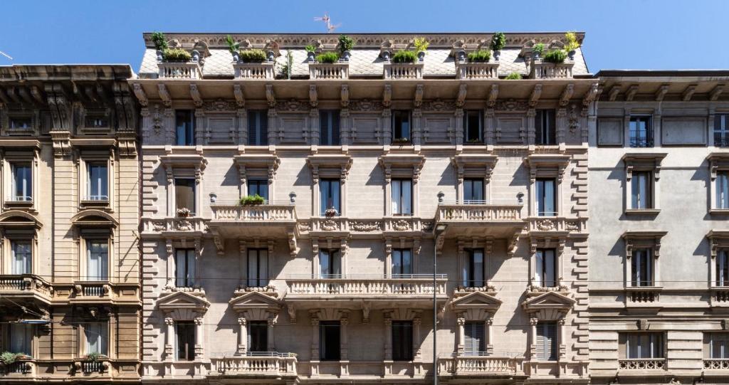 ein Apartmenthaus mit Topfpflanzen auf dem Dach in der Unterkunft Le Dimore Suites Milano in Mailand