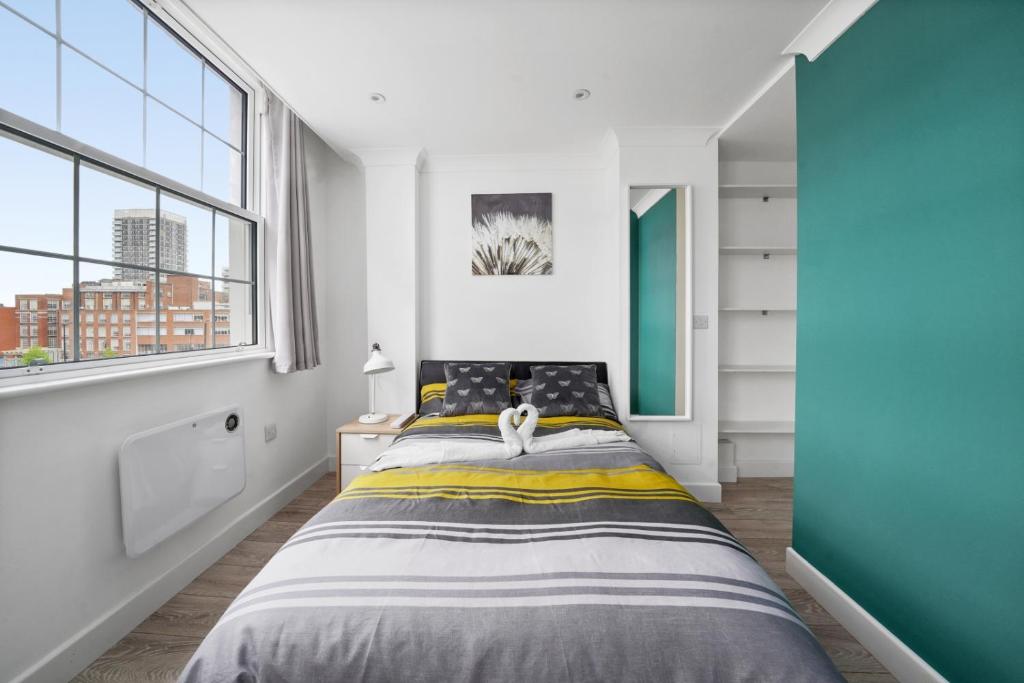 a bedroom with a bed and a large window at STUDIO IN THE HEART OF THE CITY - ALDGATE ZONE 1 in London