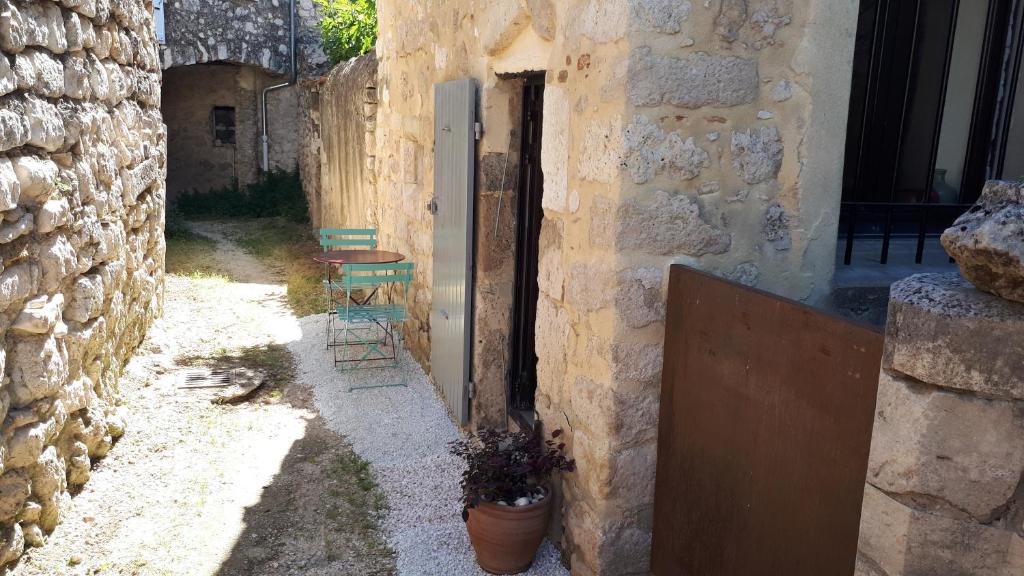 un edificio de piedra con una puerta y una maceta en Gîte de village, en La Garde-Adhémar
