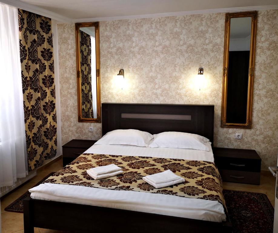 a bedroom with a large bed with two towels on it at Panzió STATUS in Hajdúszoboszló
