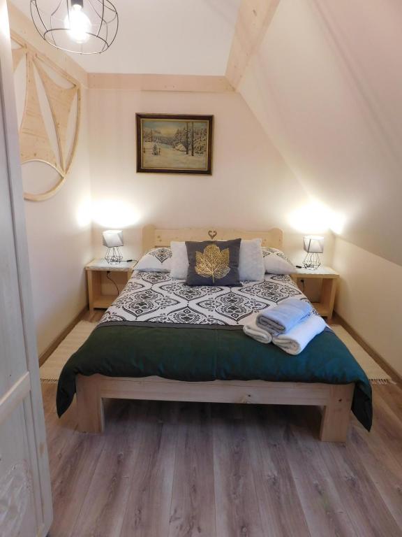 a bedroom with a large bed with two night stands at Apartament w Równi in Chochołów