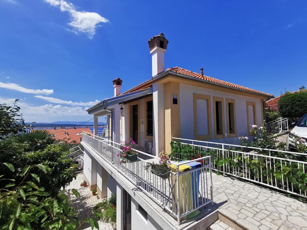 a house on a balcony with a view of the beach at Apartments Balticadriatic in Dramalj