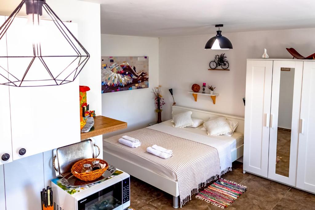 een kleine slaapkamer met een bed en een televisie bij Little garden house in Rijeka