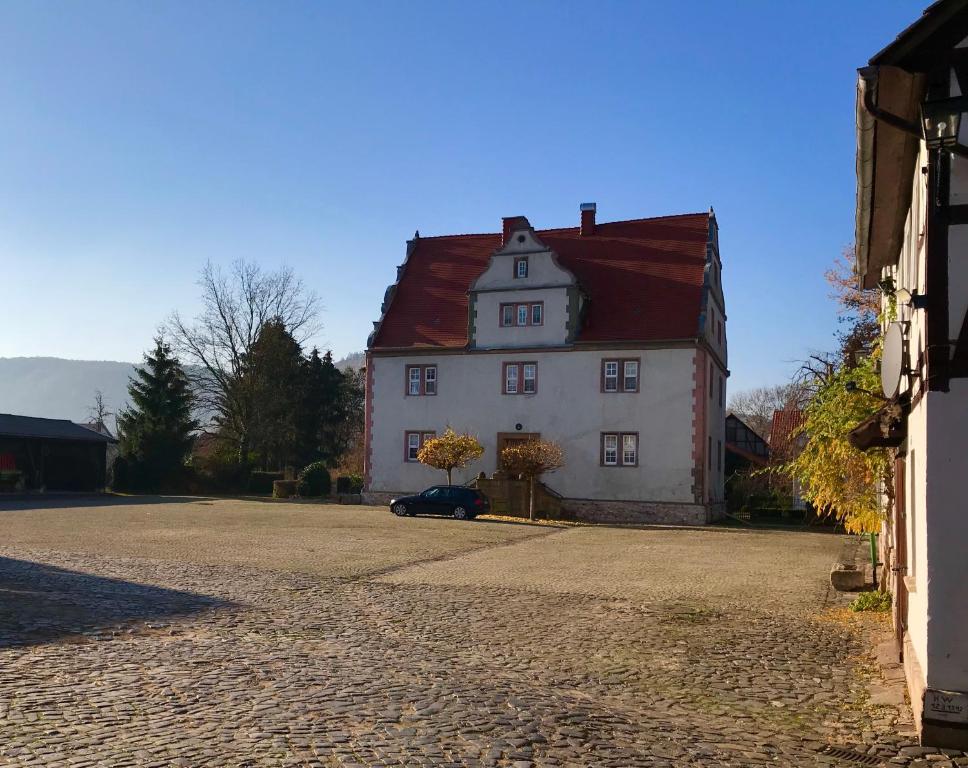a large white house with a red roof at Rittergut Kleinvach in Kleinvach