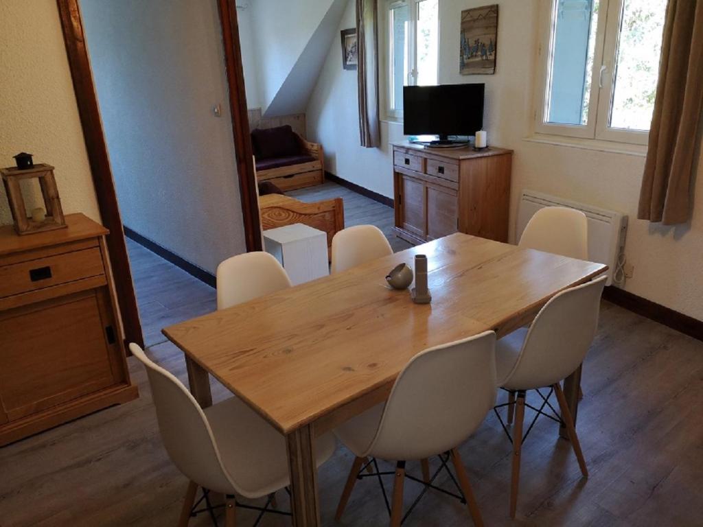 a dining room with a wooden table and chairs at Résidence Perce Neige in Luz-Saint-Sauveur