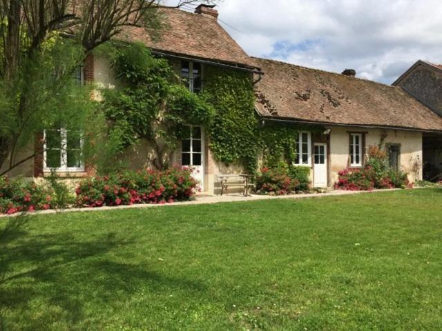 une maison avec une cour d'herbe devant elle dans l'établissement le Clos de la Livre, à Fontaine-sur-Ay