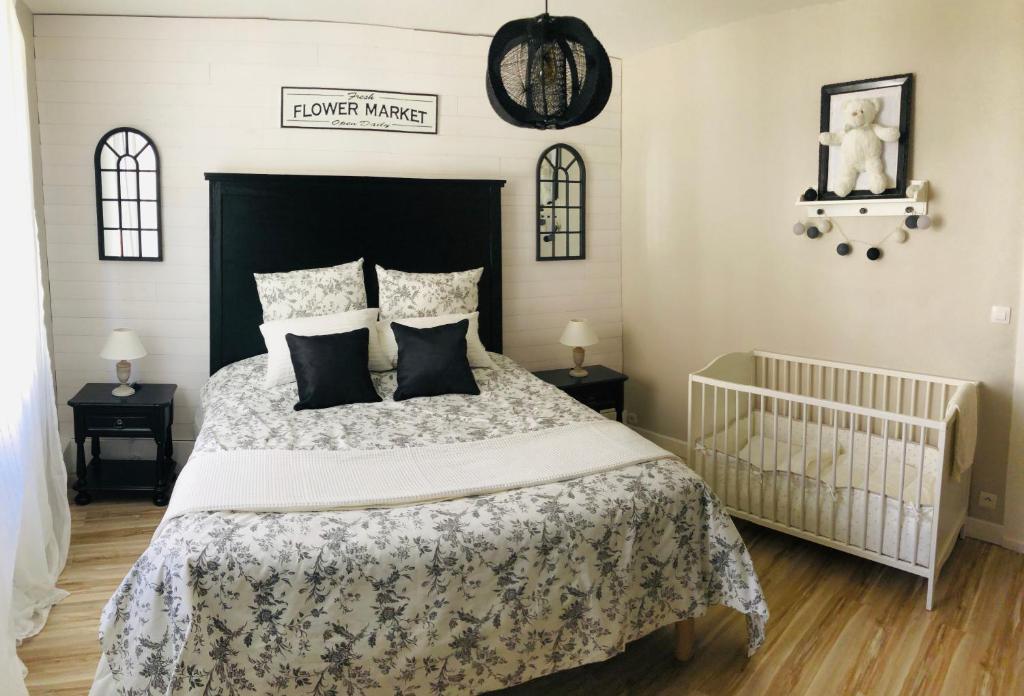 - une chambre avec un grand lit et un lit bébé dans l'établissement "La Vigne Dort" Cocon romantique, à Herrlisheim-près-Colmar