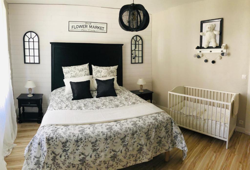 a bedroom with a large bed with a crib at "La Vigne Dort" Cocon romantique in Herrlisheim-près-Colmar