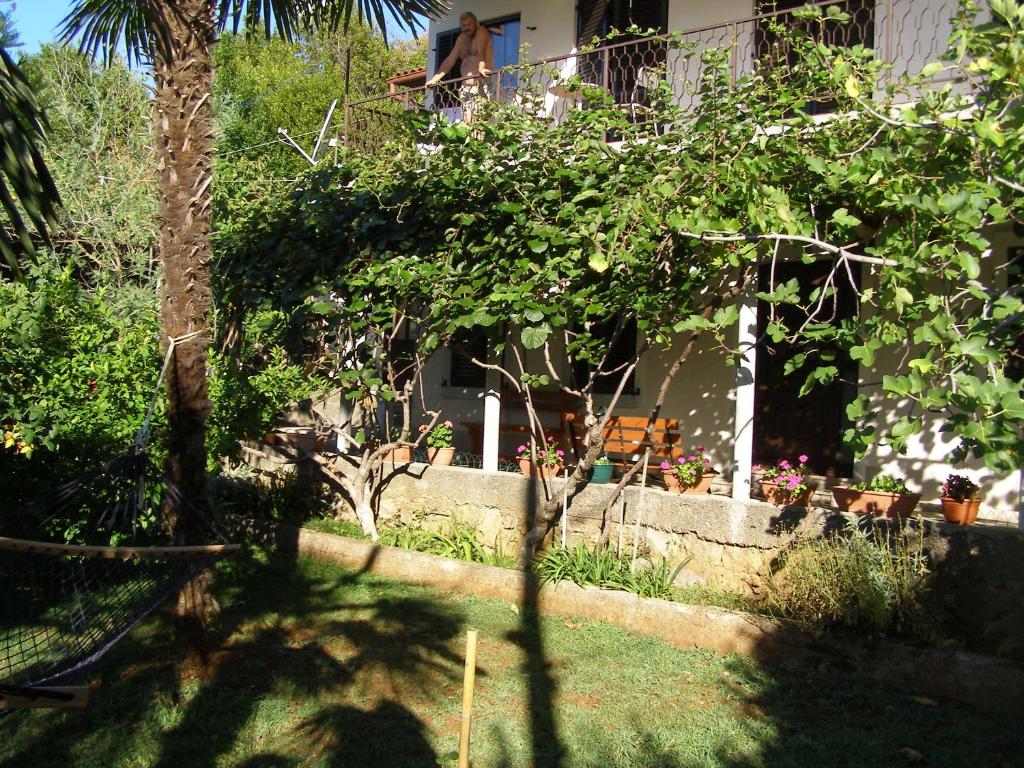 a garden with trees and chairs in front of a house at Apartment Gianfranko in Opatija