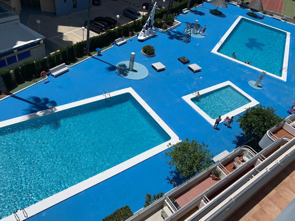 einen Blick über einen großen Pool mit blauem Wasser in der Unterkunft SERVICE APART LAZARO- Apartamentos Aguamarina 58 in Calpe