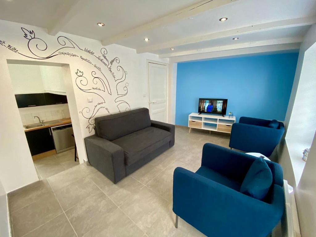 sala de estar con sofá y 2 sillas azules en La petite maison à deux pas de la mer, en Wimille