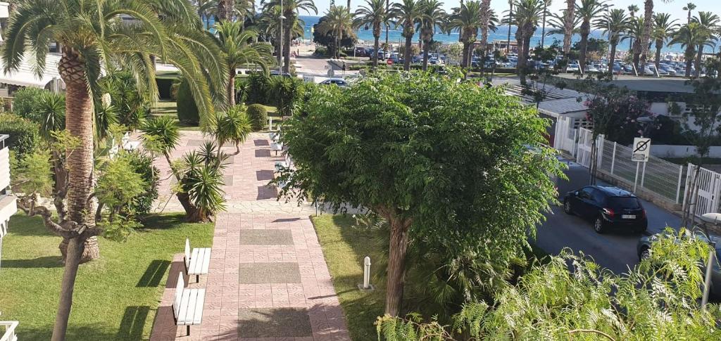 una vista aérea de un parque con palmeras y un coche en Encantadora vivienda en el paseo marítimo de Salou, en Salou