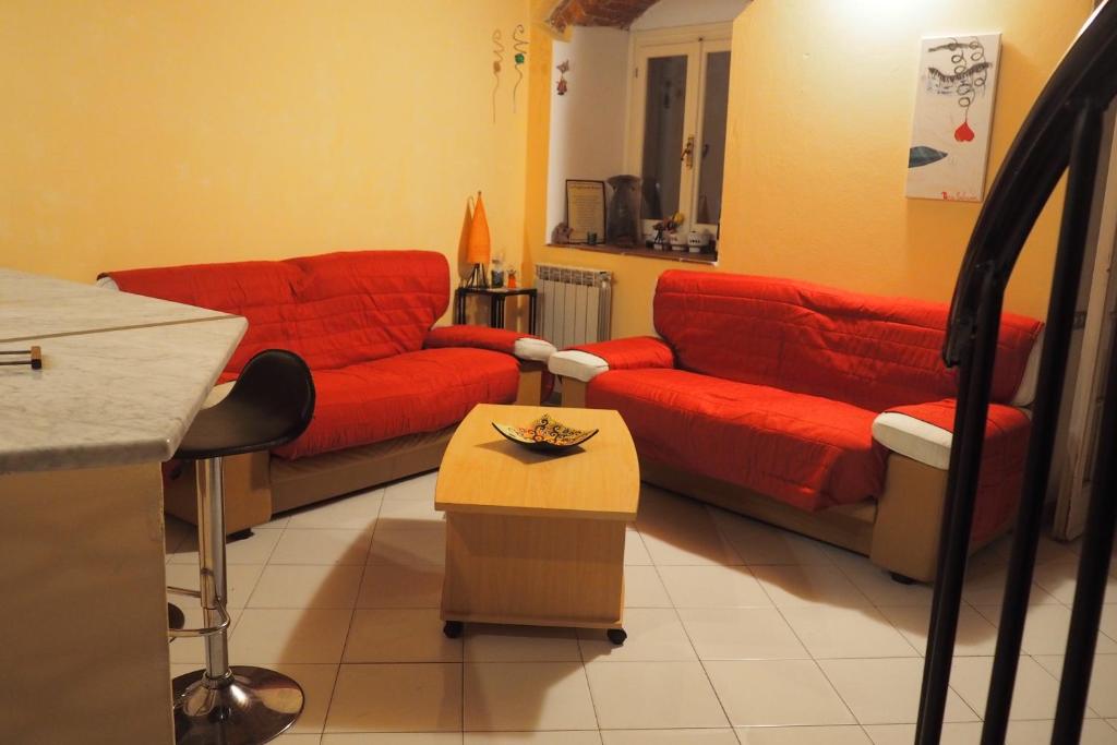 un soggiorno con divani rossi e tavolo di Casa Morè a Carrara