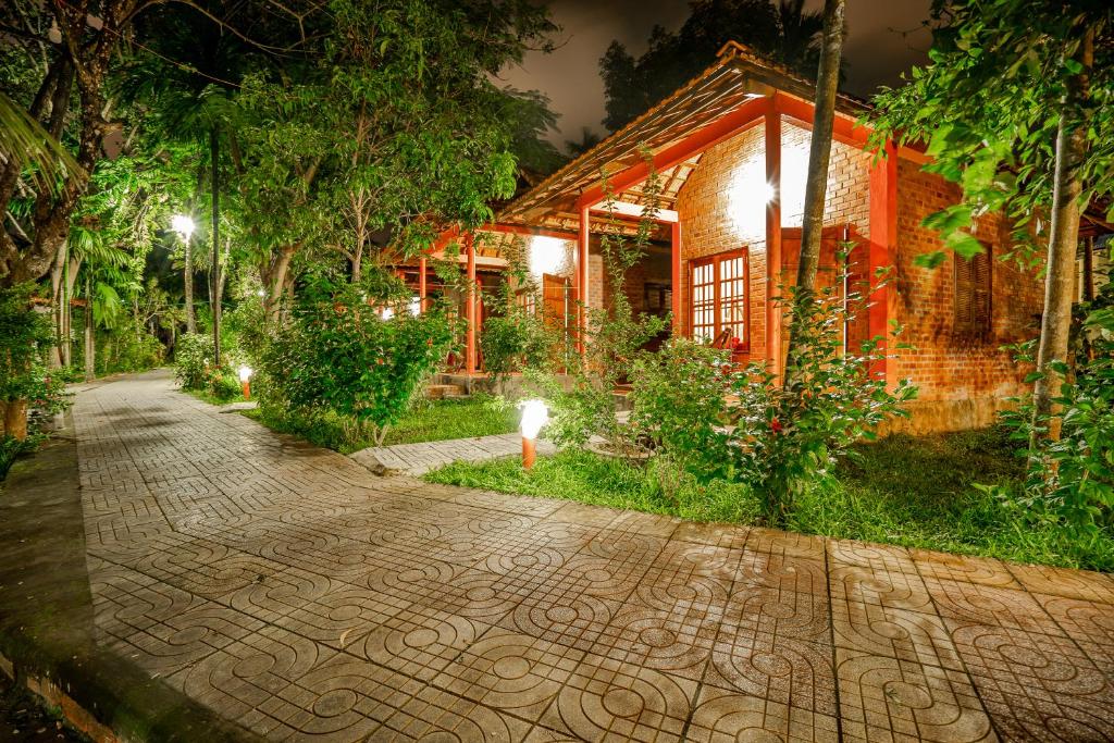 uma passarela de tijolos em frente a uma casa à noite em Huong Giang Bungalow em Phu Quoc