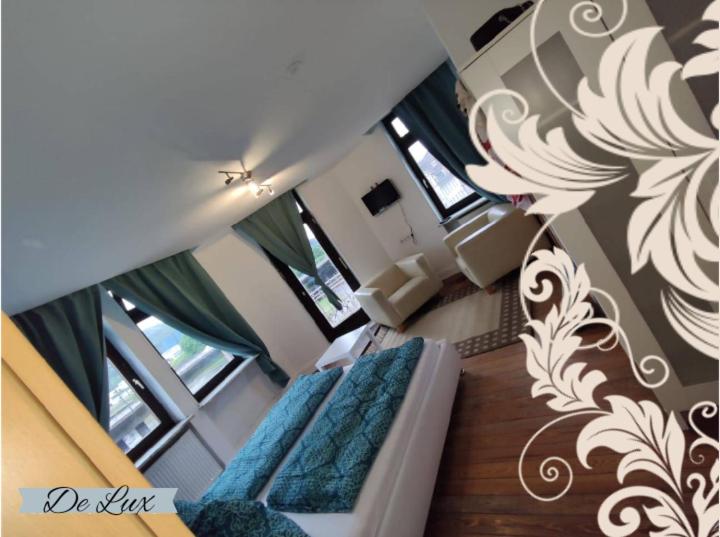 ein Wohnzimmer mit einem Sofa und einigen Fenstern in der Unterkunft De Lux Gästehaus Völklingen in Völklingen