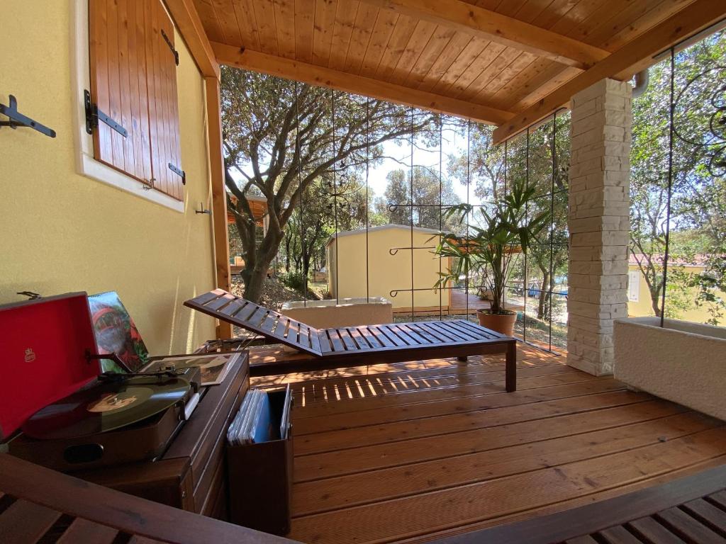 a screened in porch with a bench on a deck at Campsite Piccolo in Banjole