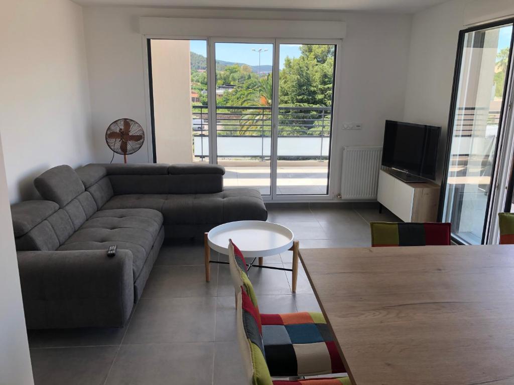 un salon avec un canapé et une table dans l'établissement Appartement T3 neuf Sur les toits avec terrasse, à Hyères