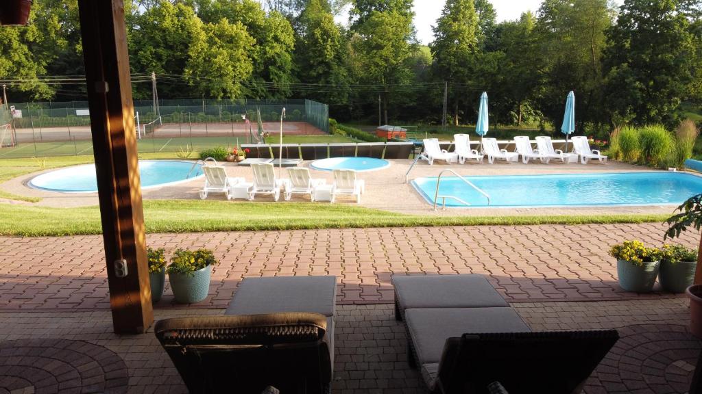 a view of a swimming pool with chairs and a table at Agroturystyka Willa Maria in Bystrzyca Kłodzka