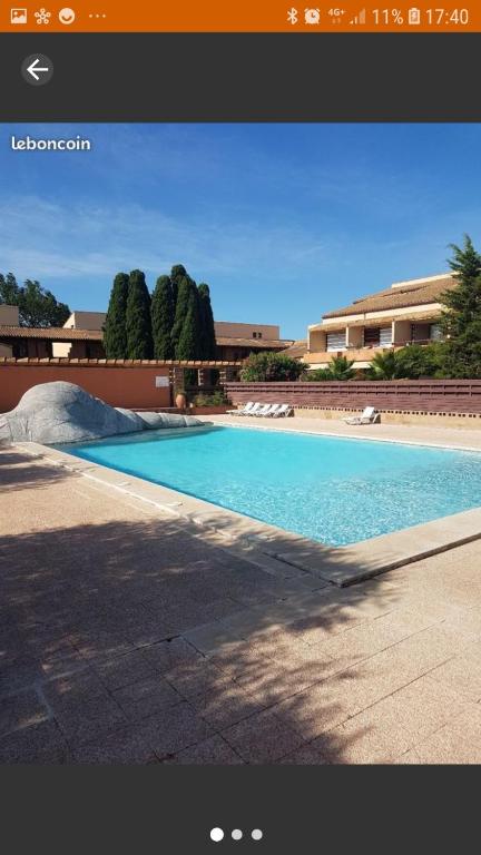 une grande piscine bleue devant un immeuble dans l'établissement Appartement piscine golf, à Saint-Cyprien