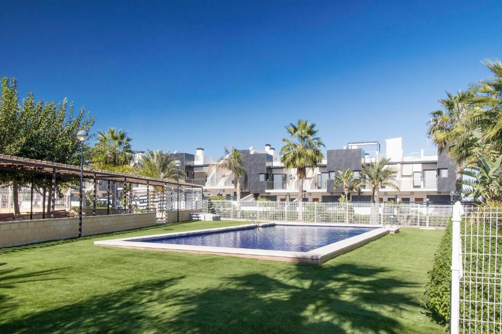basen na środku trawnika z palmami w obiekcie Royal Park w mieście Torrevieja