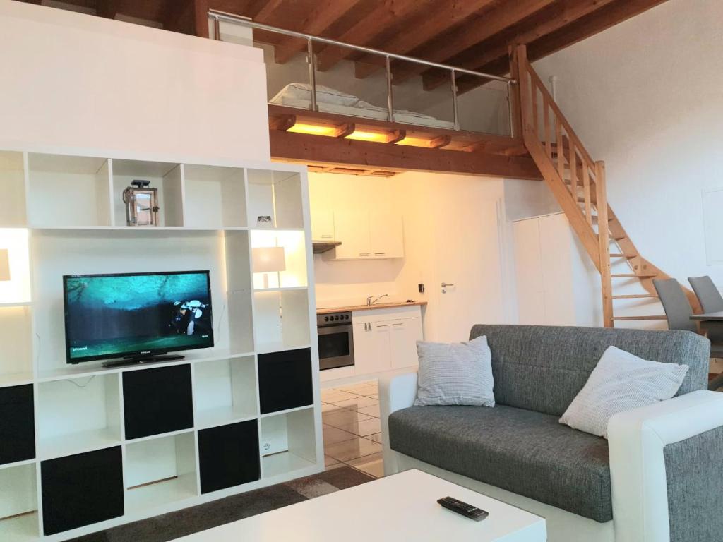 - un salon avec un canapé et une télévision dans l'établissement Ferienwohnung Loft ca. 45 qm, à Anröchte