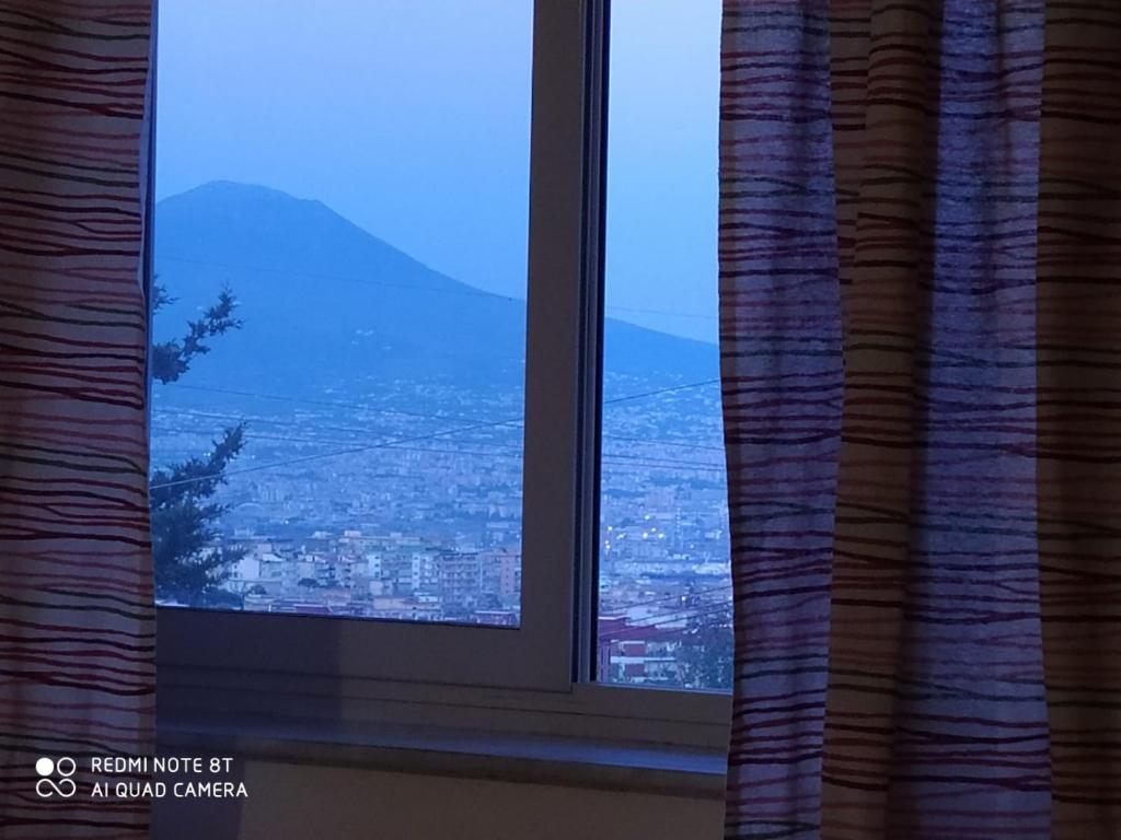 a window with a view of a city at Una nuova luna ai Camaldoli in Naples