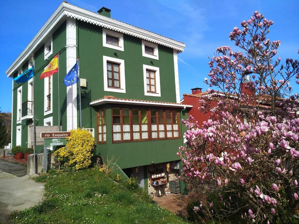 un edificio verde con flores delante en Hotel Casa Vieja del Sastre, en Soto de Luiña