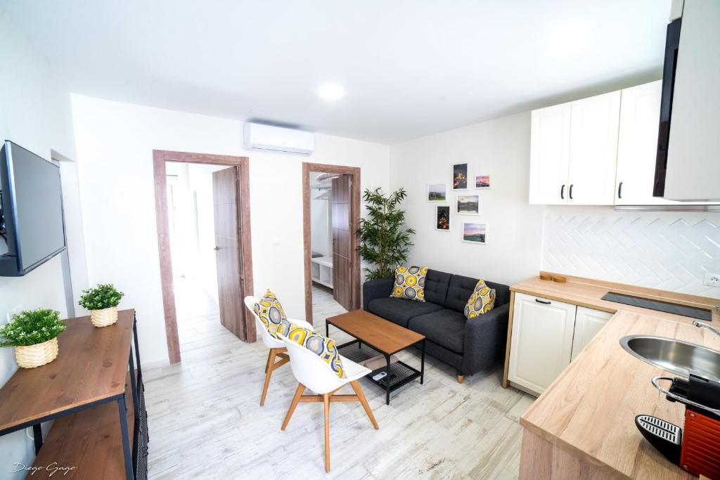 a kitchen and living room with a couch and a table at Apartamento Arcos in Arcos de la Frontera