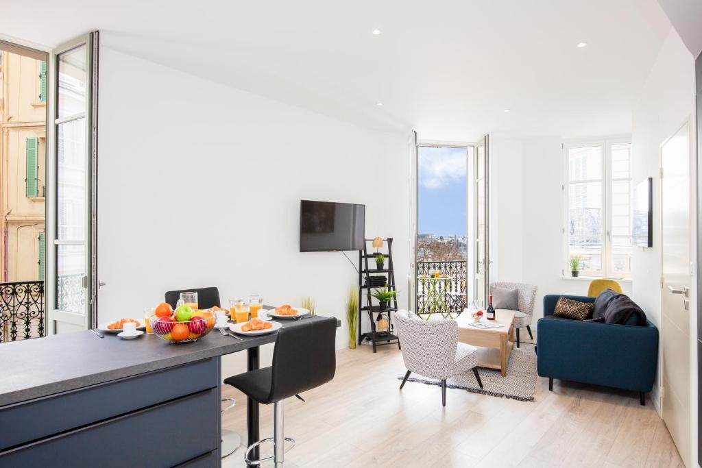 een keuken en een woonkamer met een tafel met fruit erop bij Astoux YourHostHelper in Cannes
