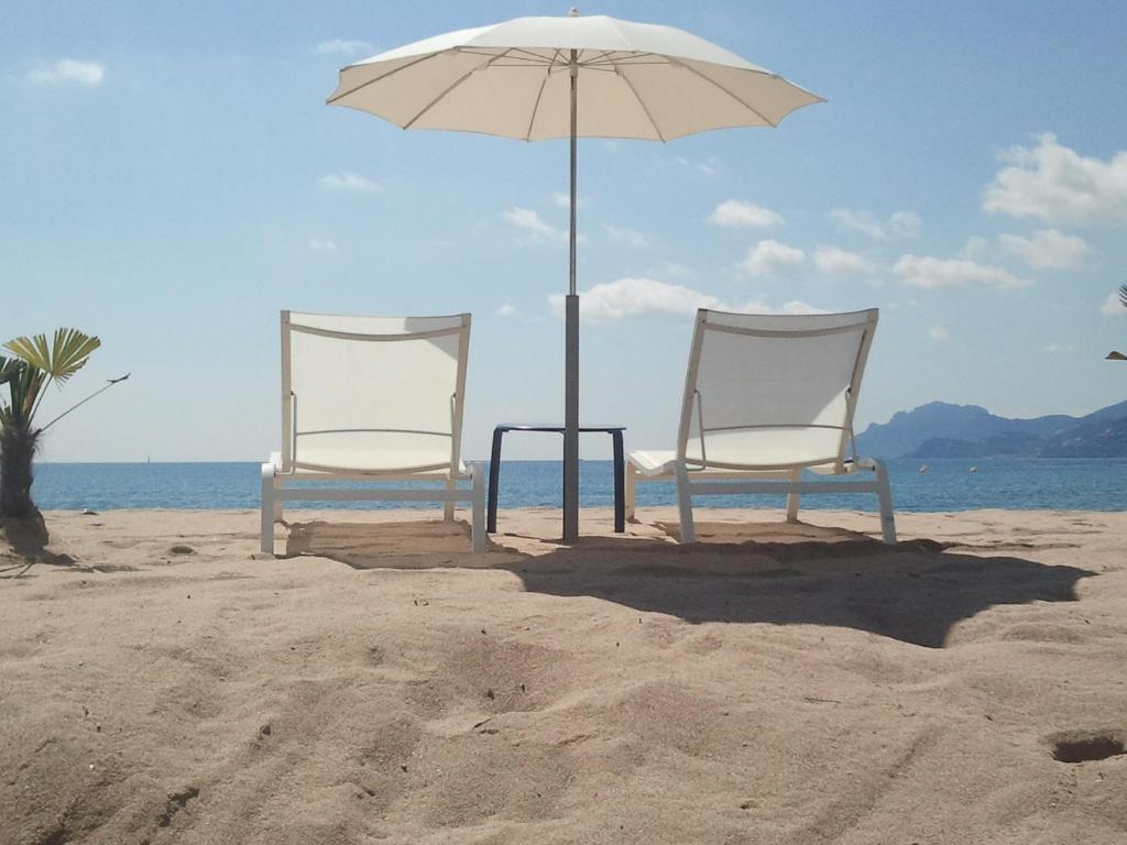- deux chaises et un parasol sur la plage dans l'établissement Appartement Cannes à quelques pas de la mer, de la Croisette et du Palais des Festivals, à Cannes