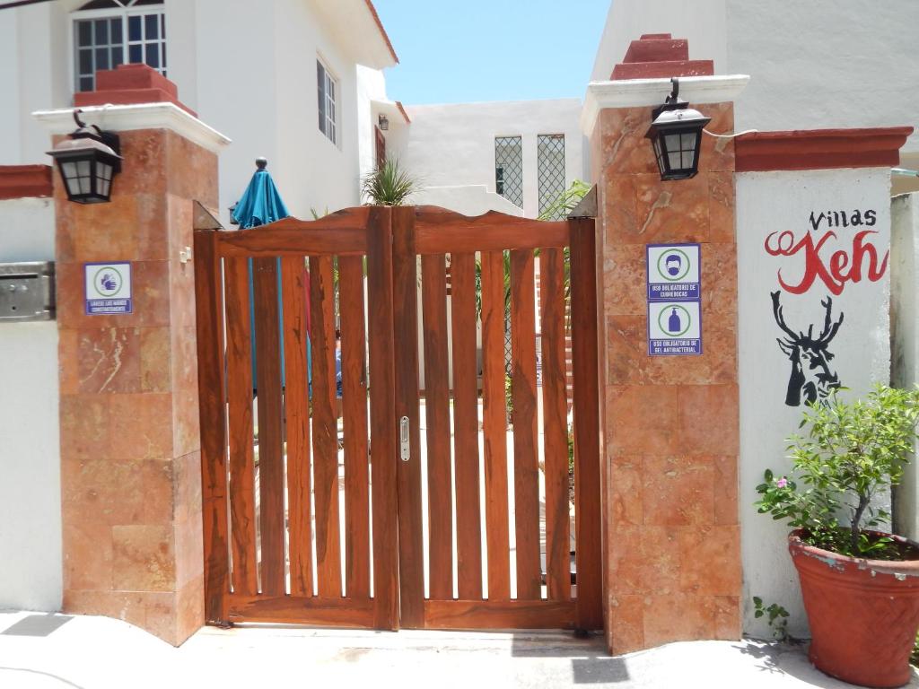 um portão de madeira em frente a uma casa em Villas Keh em Isla Mujeres