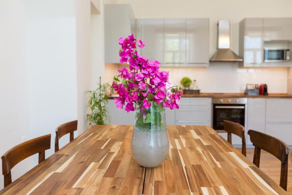 a vase filled with purple flowers sitting on a wooden table at Dal Dottore in Corfu