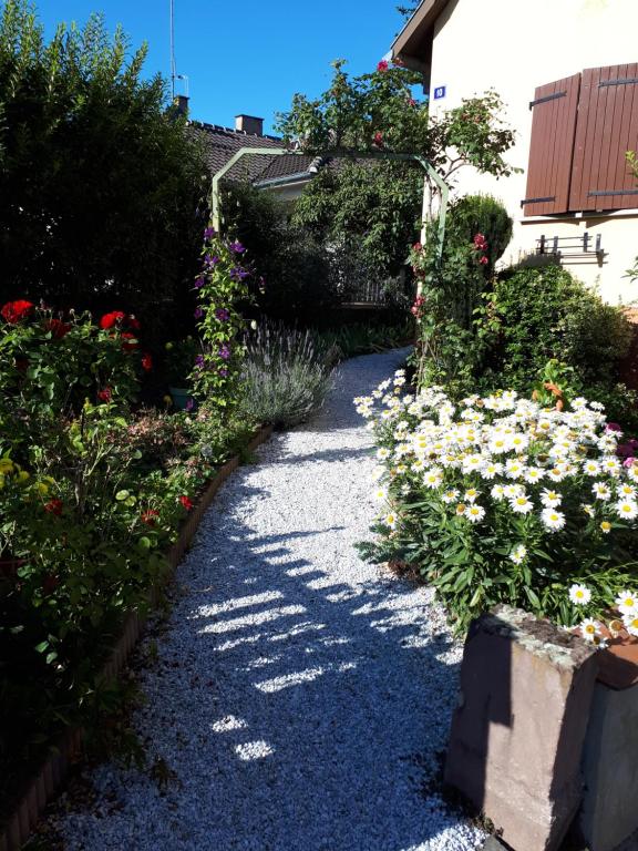 un camino de grava con flores en un jardín en Le chouette gîte, en Sélestat