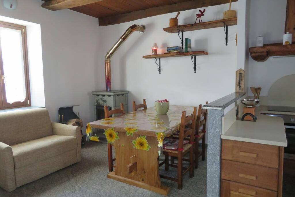 a living room with a table and a kitchen at Il Girasole in Montecrestese
