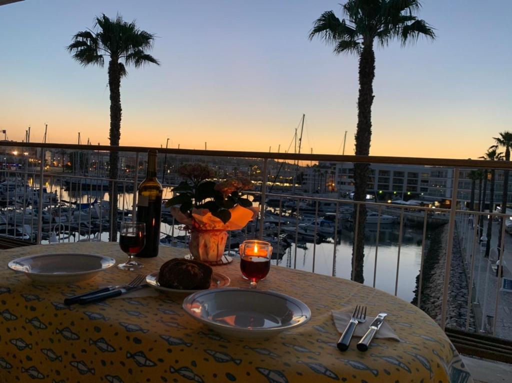 un tavolo con due bicchieri di vino e una vista sul porto di Lagos Marina - Exclusive Apartment with a Balcony a Lagos