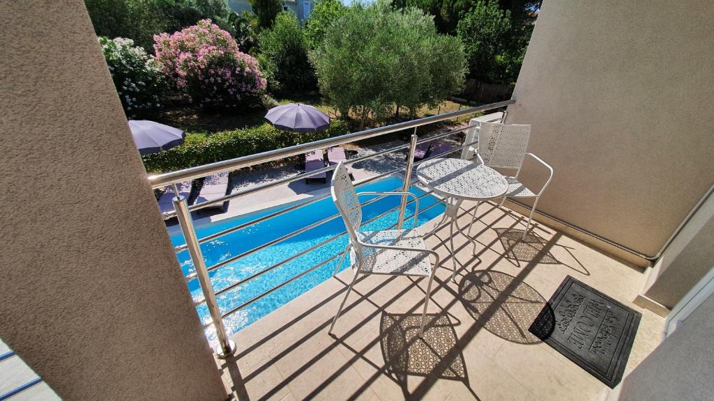 uma vista para uma piscina com cadeiras e guarda-sóis em Villa Merra em Premantura