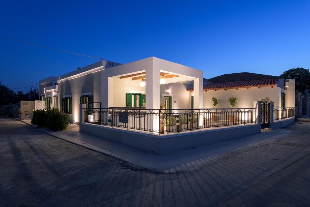 uma casa branca com uma varanda à noite em Kite Blue Villas em Kattavía