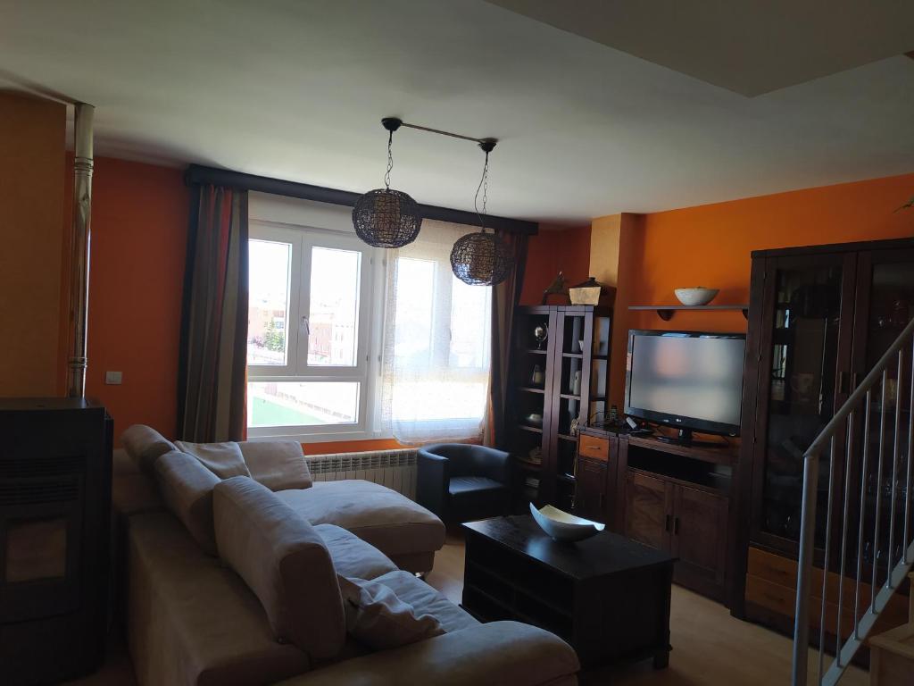 sala de estar con sofá y TV en Casa mireia en Soria