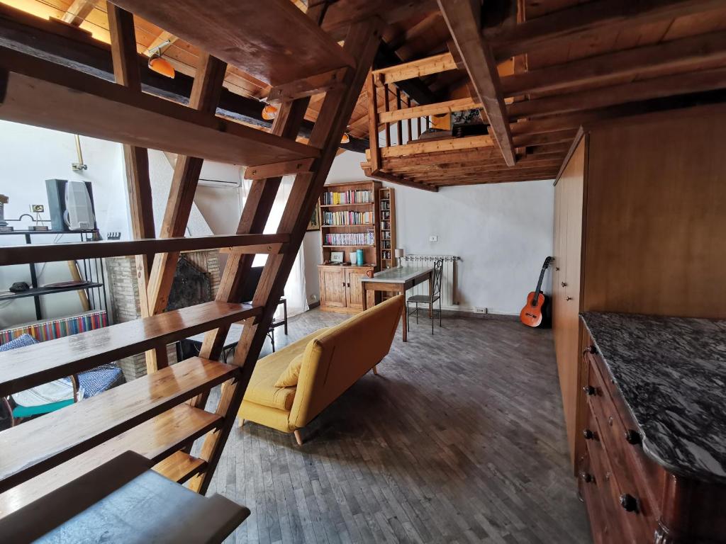 sala de estar con techos de madera, sofá y escritorio en Casa Con Soppalco ad Ariccia, en Ariccia