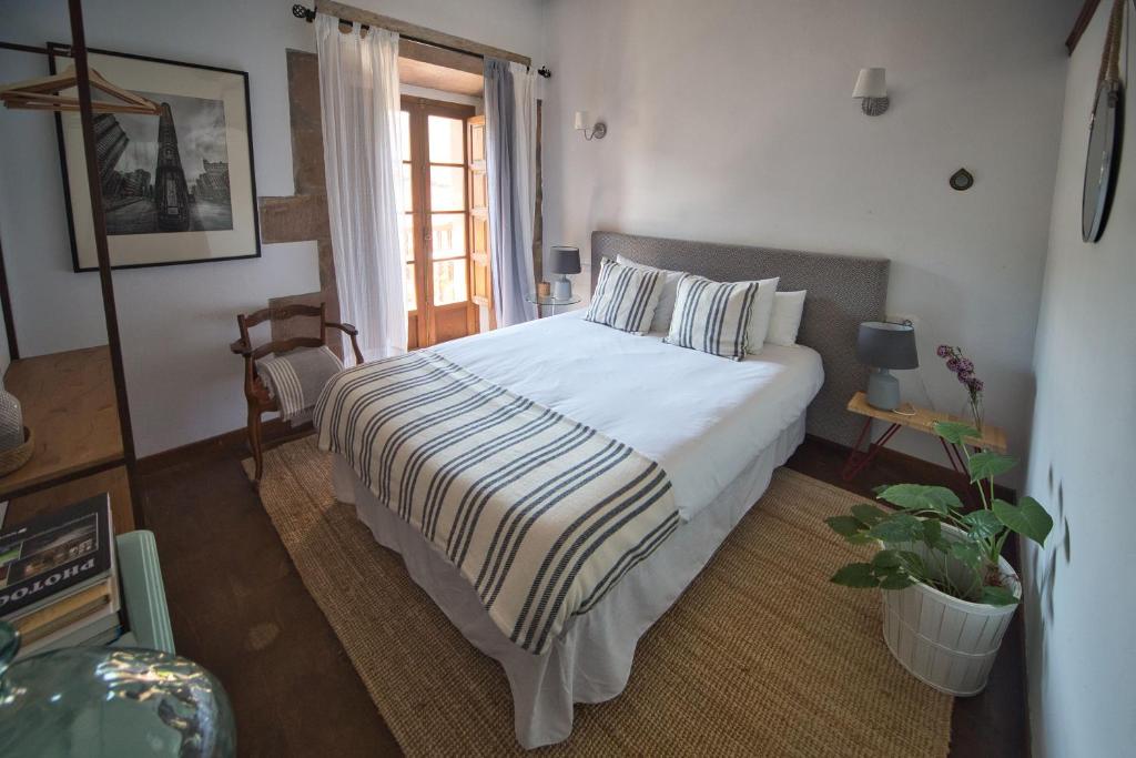 a bedroom with a bed with a striped blanket at La Infinita Rural Boutique in Carmona