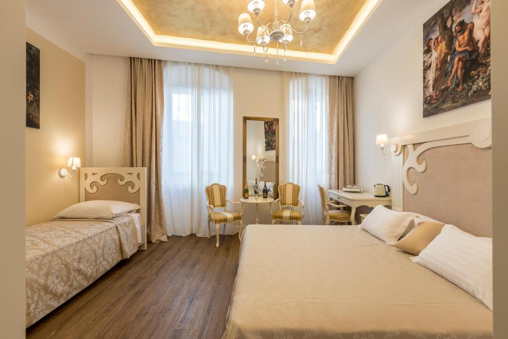 a hotel room with two beds and a dining area at Palace of Dreams Rooms in Split