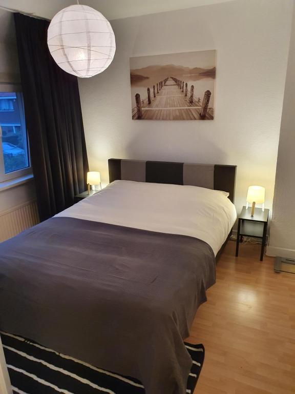 ロッテルダムにあるSingle family home in Hillegersberg - Schiebroekのベッドルーム1室(大型ベッド1台、ランプ2つ付)