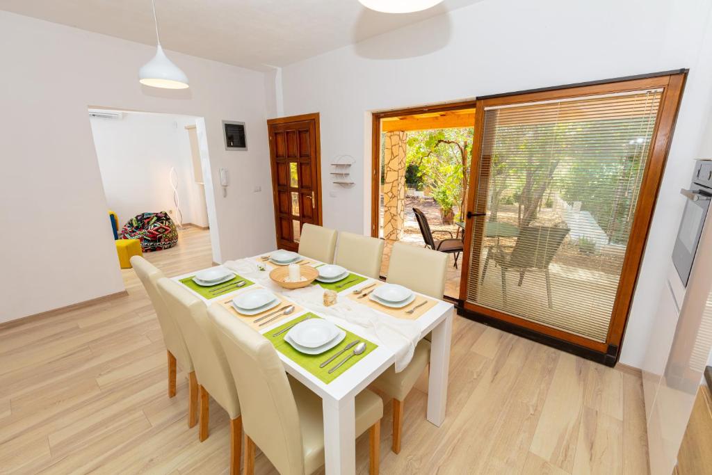 a dining room with a white table and chairs at Al Pino Blue Property in Premantura