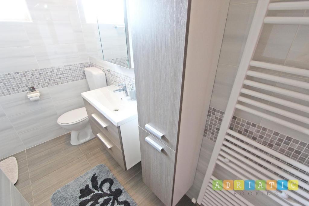 穆泰爾的住宿－apartman klaudijo，白色的浴室设有卫生间和水槽。