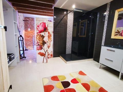 a bathroom with a shower and a vase of flowers at Maison Small Luxury ( planxa,suite,solarium,jacuzzi,pas de vis à vis) in Argelès-sur-Mer
