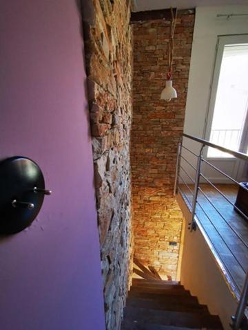 a room with a brick wall and a stair case at Maison Small Luxury ( planxa,suite,solarium,jacuzzi,pas de vis à vis) in Argelès-sur-Mer