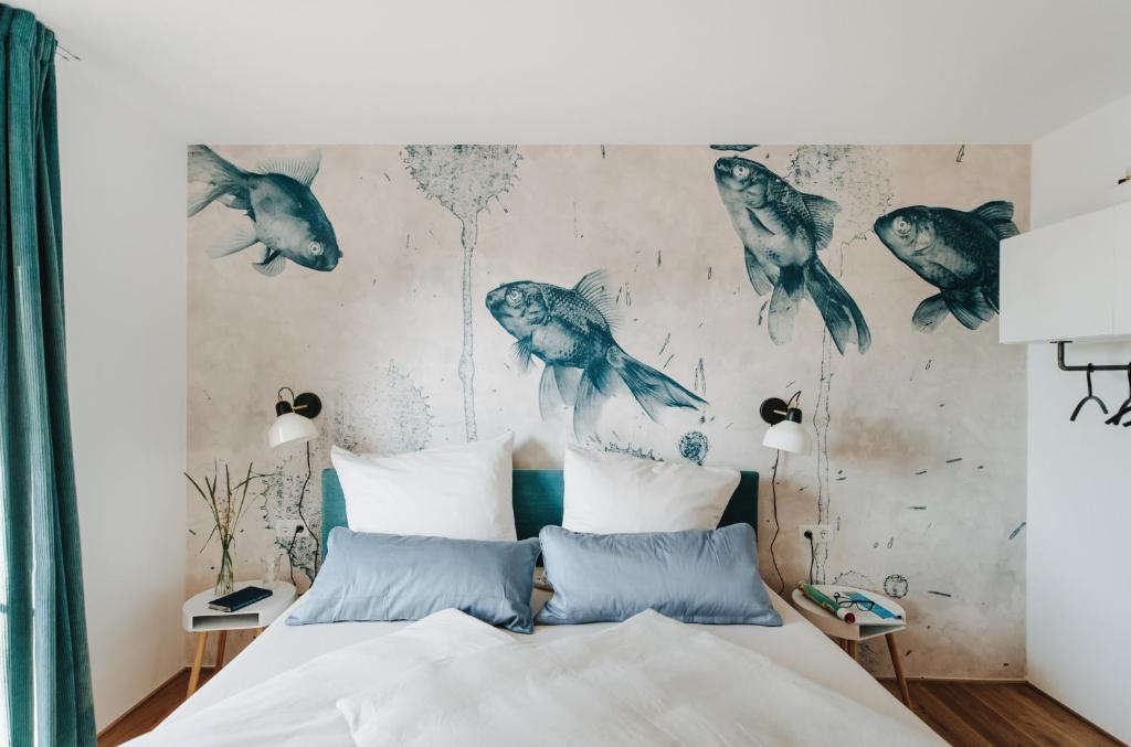 a bedroom with a bed with birds on the wall at Rotes Haus Bregenz See Wohnung in Bregenz