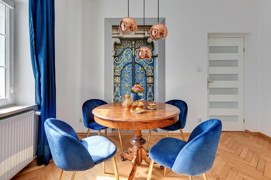 comedor con mesa de madera y sillas azules en GEDANUM Apartment OLD TOWN CENTER St.Marry Church, en Gdansk